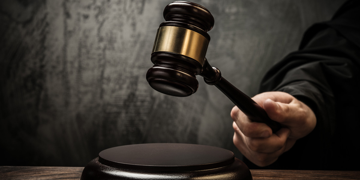 Judge holds gravel on wooden table