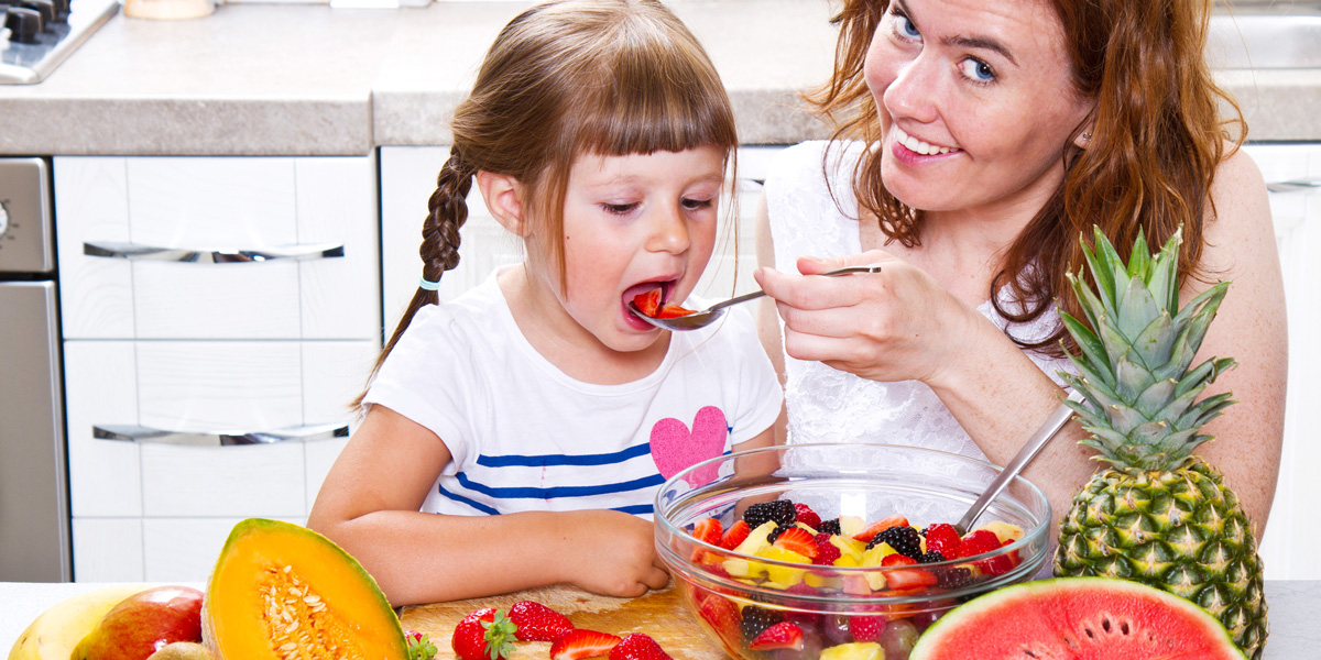 Mother Gives Fruit To Little Girl