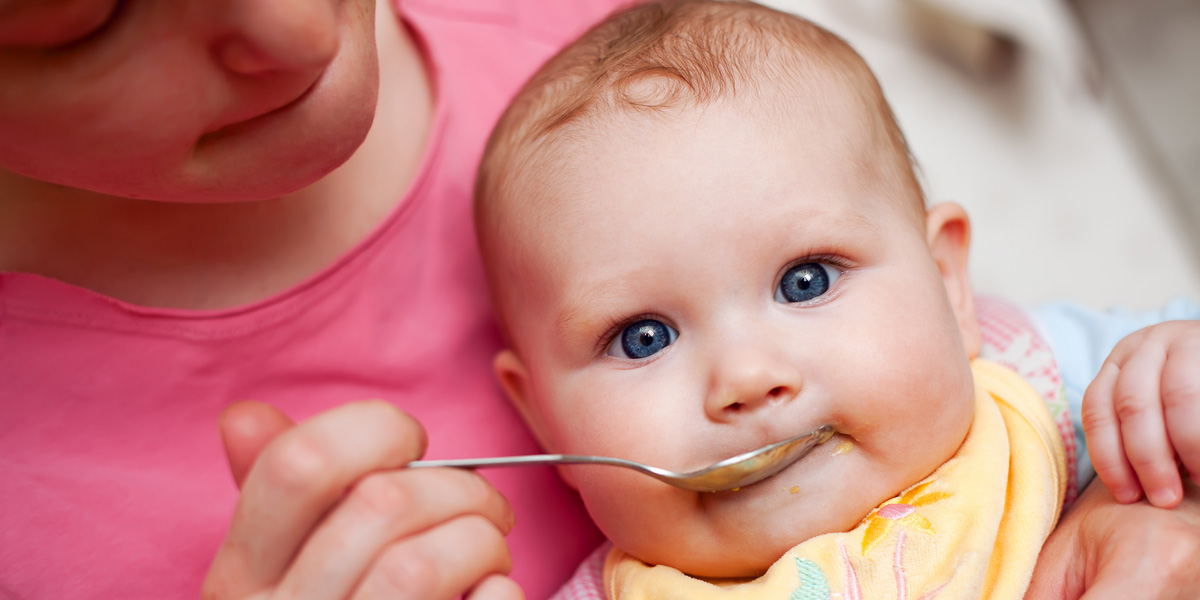 Mother feeding food to baby